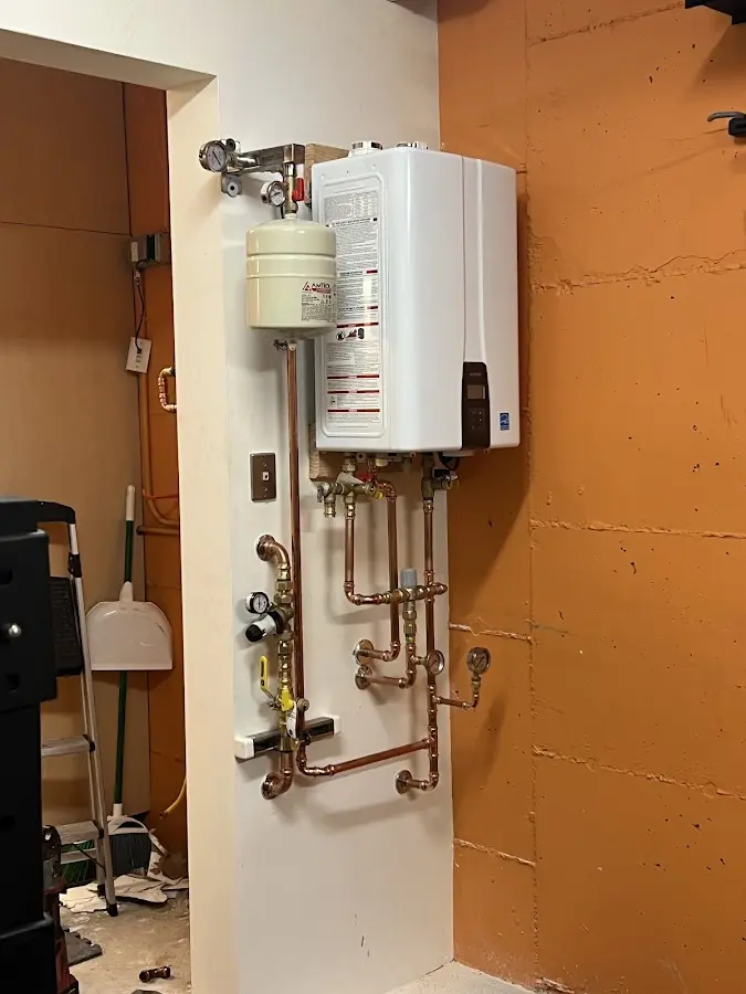 Plumbing technician inspecting water heater connections in Manti
